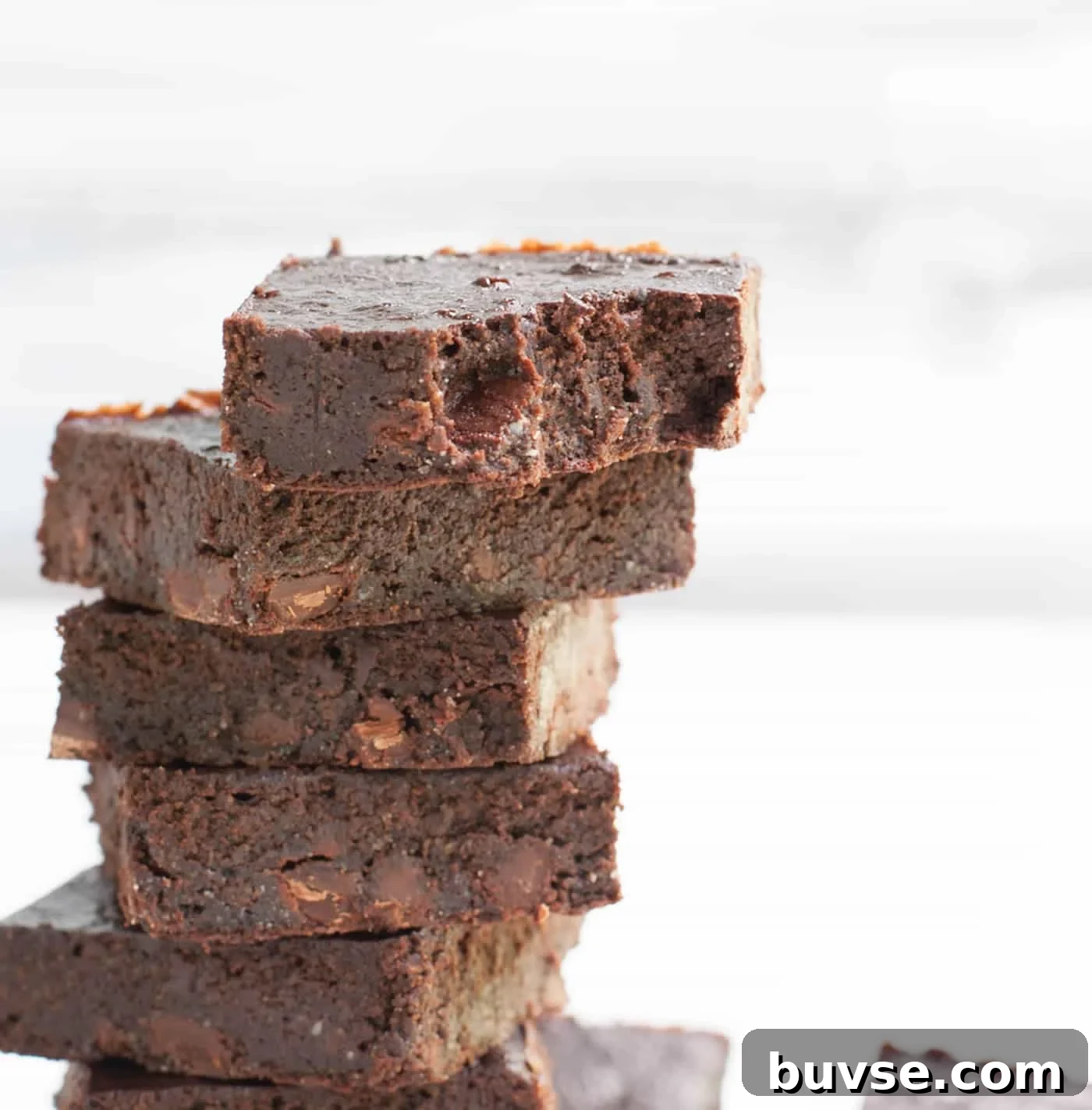 Fudgy Chocolate Zucchini Brownies Recipe 7 Stack of fudgy zucchini brownies showing dense interior.
