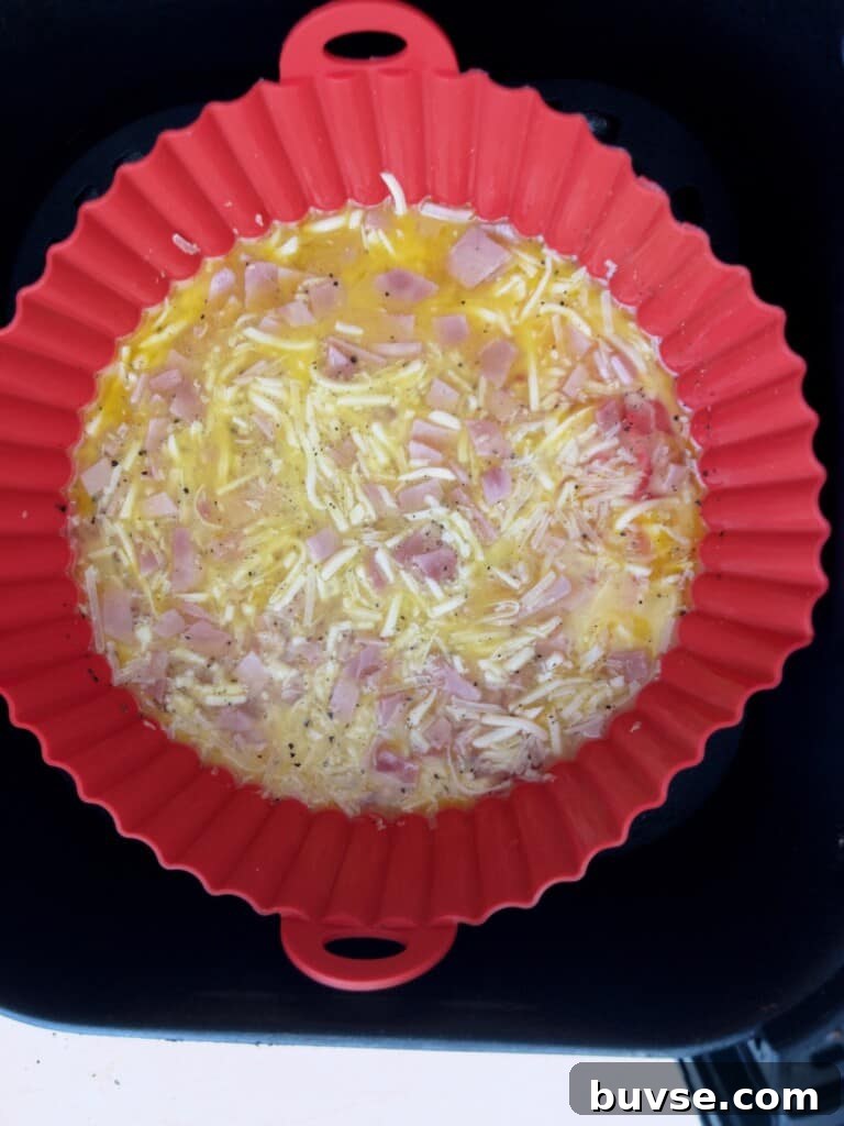 Air fryer ham and cheese omelette in air fryer basket ready to be cooked