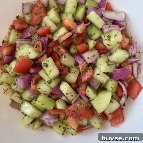 Homemade Shirazi salad made with diced cucumbers, tomatoes, red onion, dried mint, olive oil, and fresh lime juice