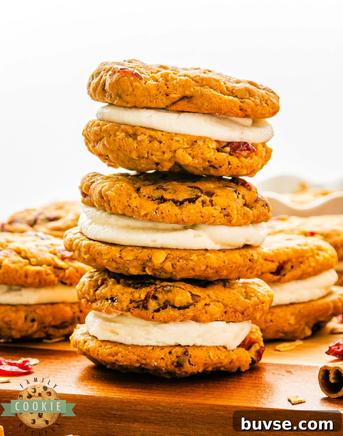 Pumpkin Oatmeal Sandwich Cookies with Cranberry Filling 5 Soft pumpkin oatmeal cookies with dried cranberries and creamy frosting filling stacked on a plate.