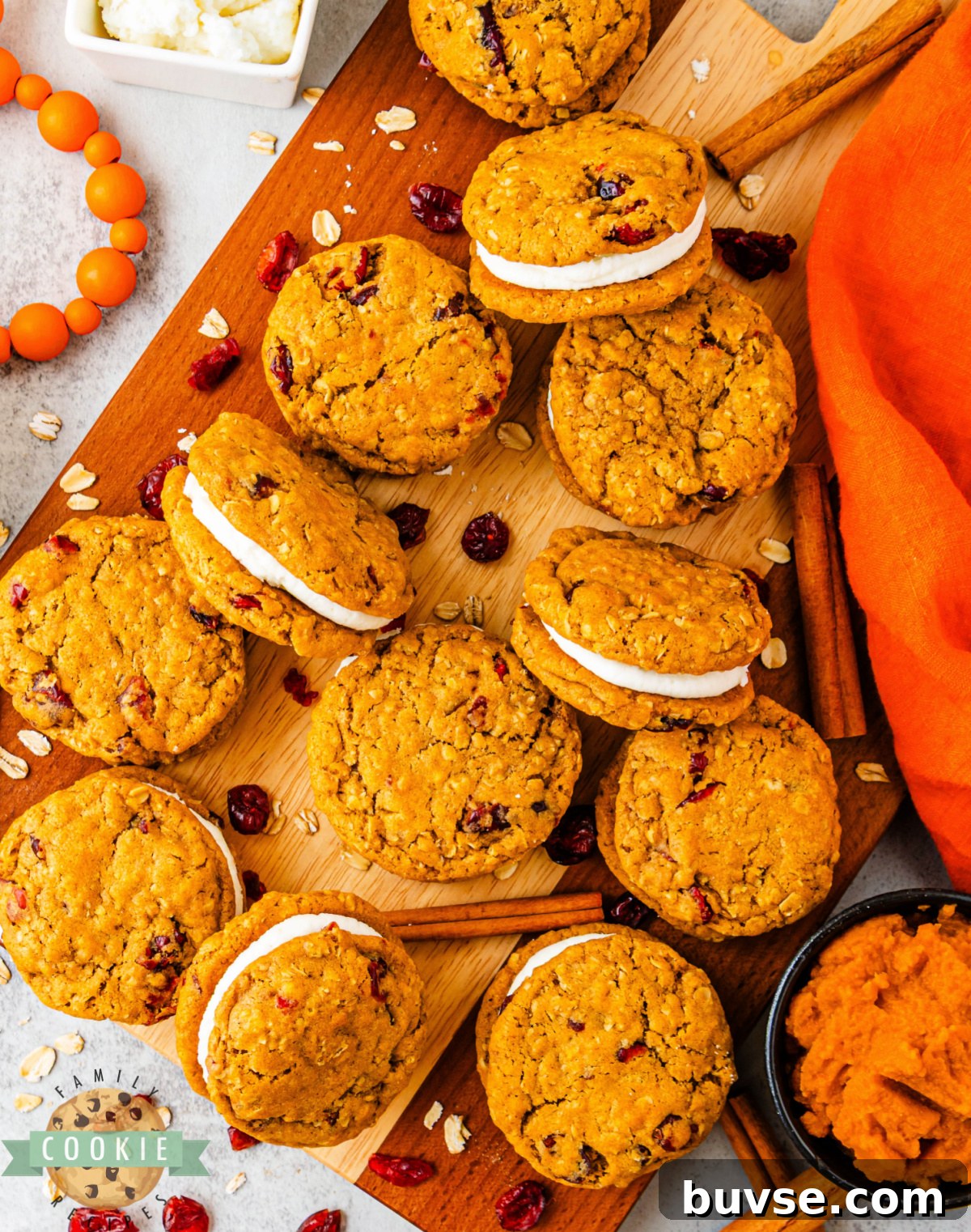 Pumpkin Oatmeal Sandwich Cookies with Cranberry Filling 6 Pumpkin oatmeal sandwich cookies showing soft centers and creamy frosting between layers.