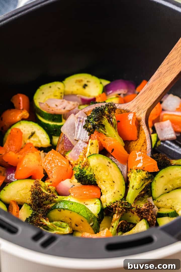 Crispy Air Fryer Vegetables: Quick Roasting Tips 11 serving the air fryer with a wooden spoon.