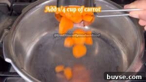 Carrot and almond halwa being prepared in a stainless steel pan.