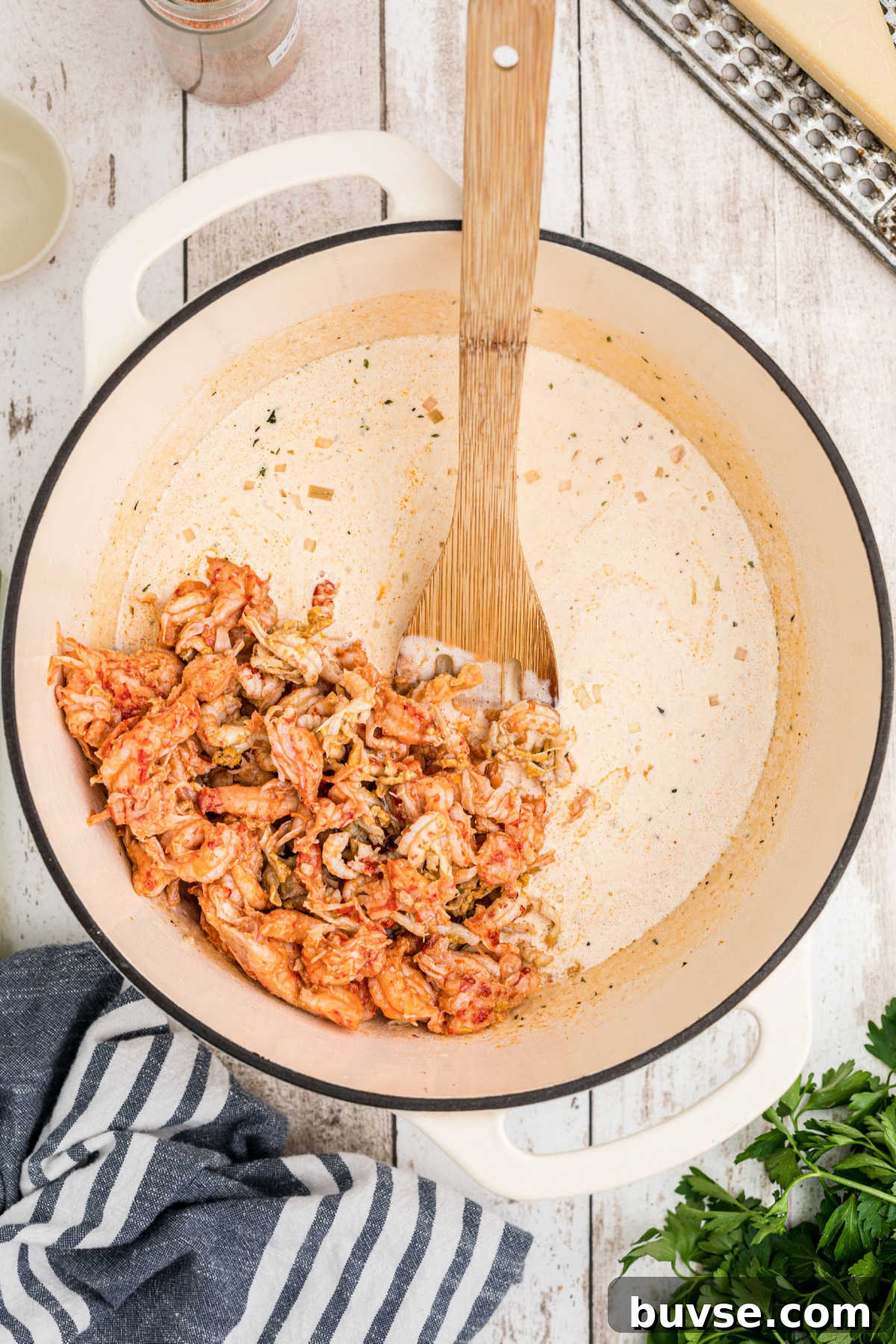 Peeled crawfish tails being added to a pot.