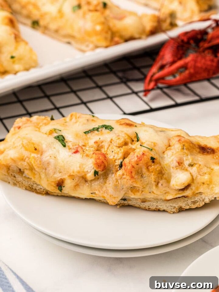a slice of crawfish bread on a plate with a cooked crawfish behind