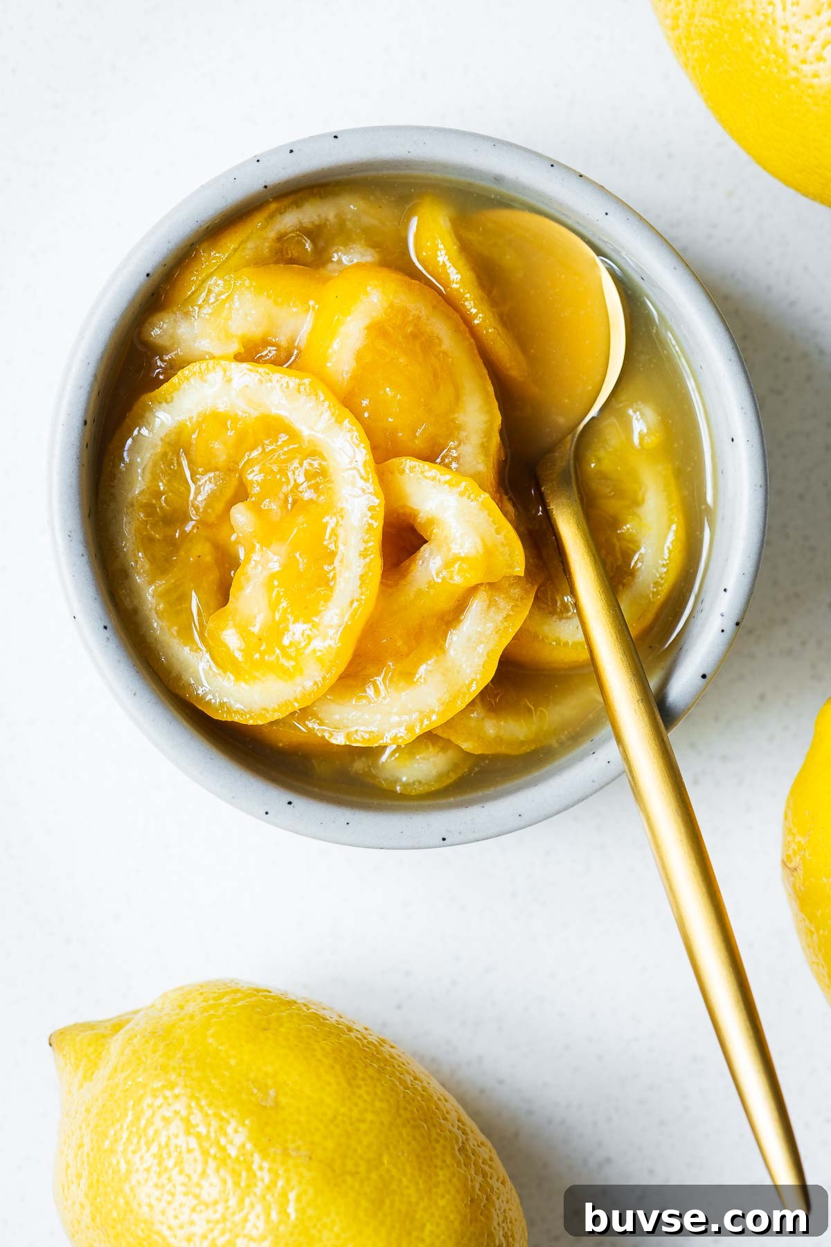 Preserved Lemon Substitute: What to Use Instead 2 Top down close-up of a ceramic bowl with preserved lemon substitute and a gold spoon.