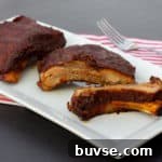 Slow braised ribs with rub and bourbon bbq sauce recipe. Cook in the oven or crock pot / slow cooker. Meat is fall off the bone tender.