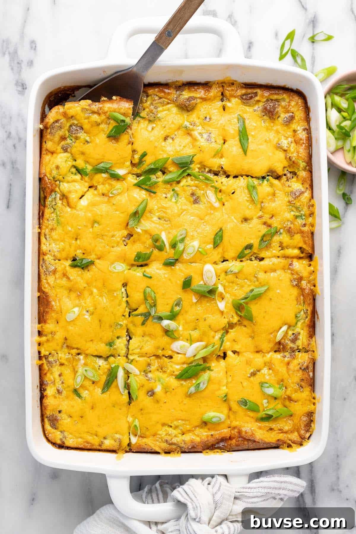 Cheesy Sausage Breakfast Casserole with Hash Browns 11 Large baking dish filled with homemade breakfast casserole recipe topped with green onion.