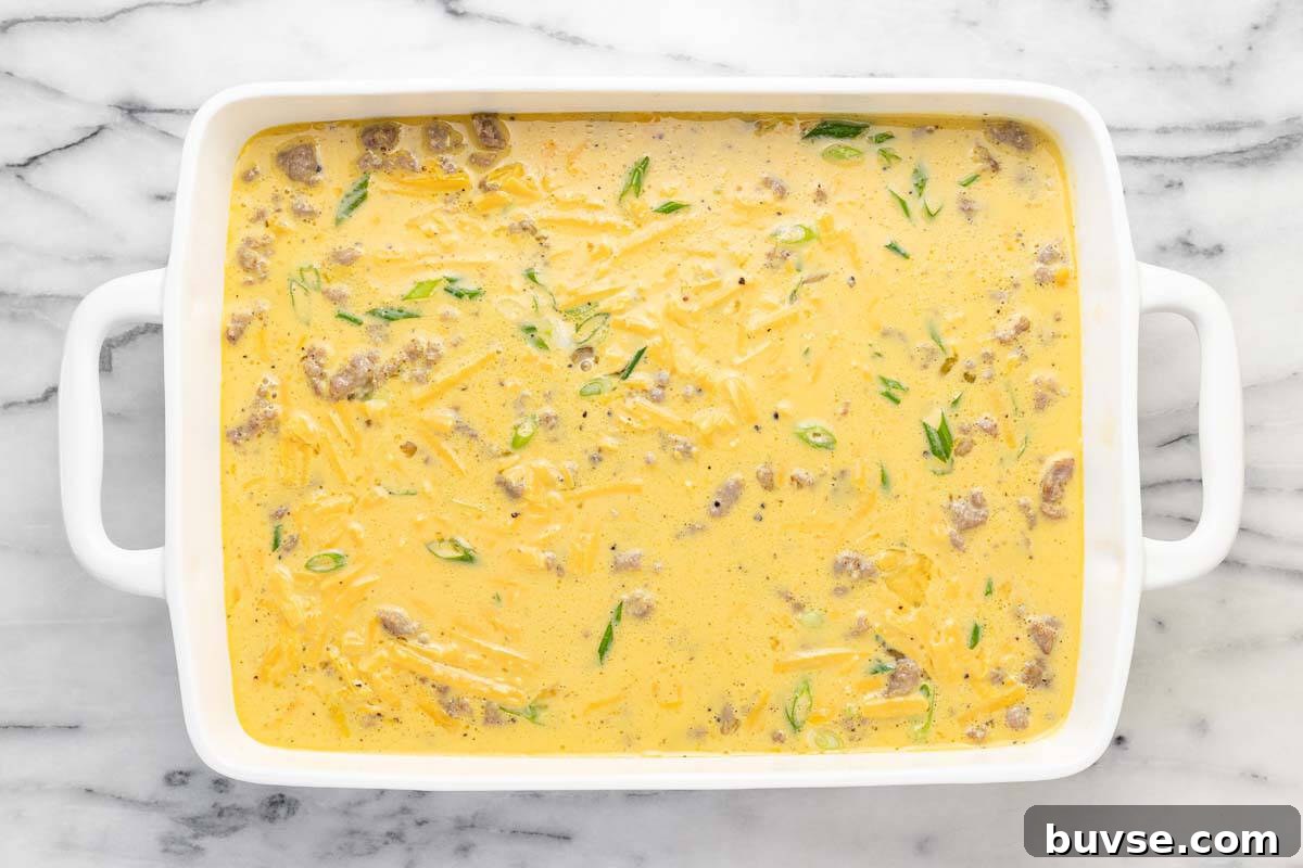 Cheesy Sausage Breakfast Casserole with Hash Browns 8 Large 9x13 baking dish filled with breakfast casserole ready for the oven.