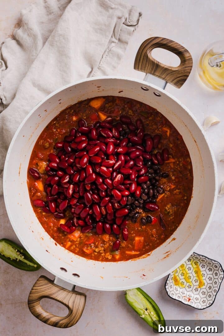 Hearty Sweet Potato Turkey Chili Recipe 6 Beans added to turkey chili in a large pot.