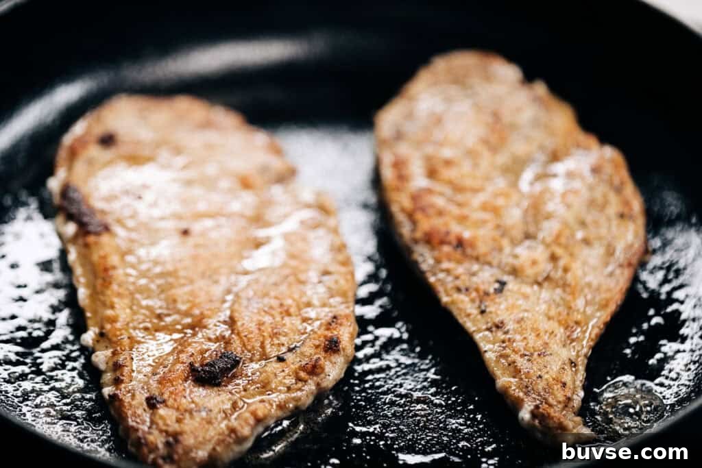 golden seared chicken in a skillet