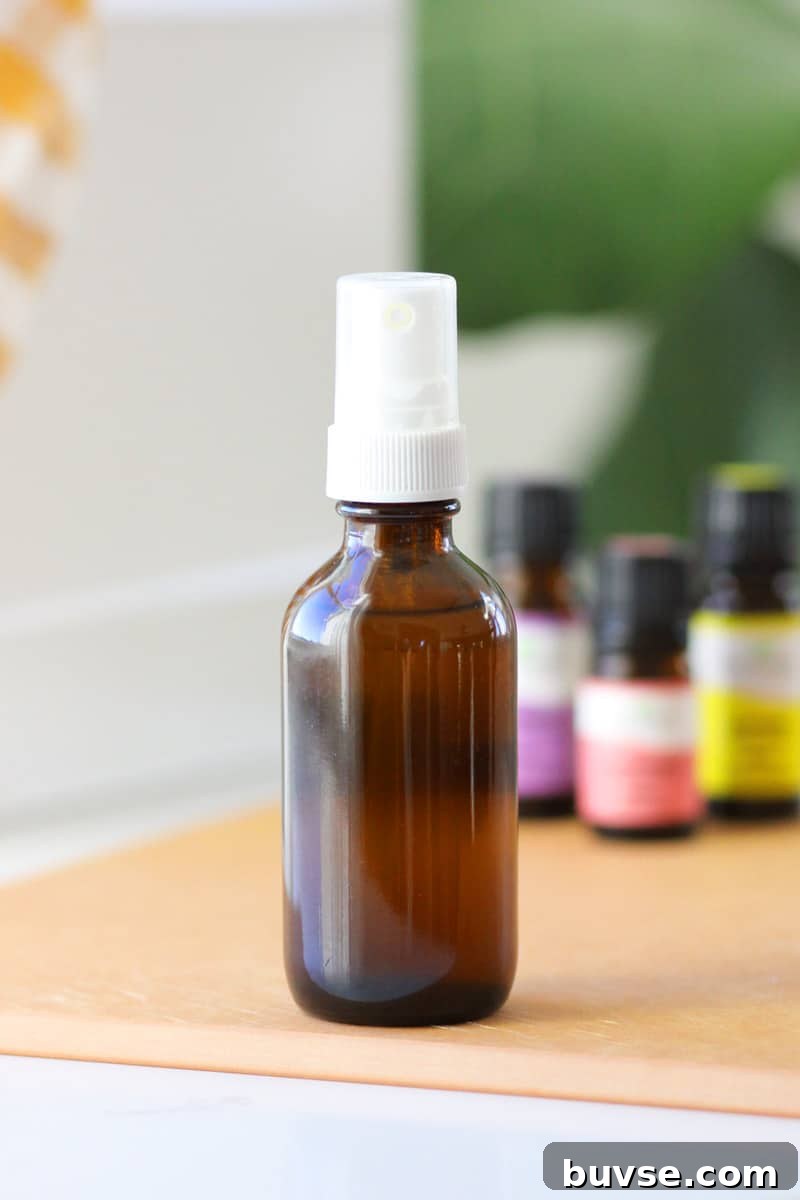 10 DIY Essential Oil Air Freshener Spray Recipes 2 a small glass amber spray bottle with essential oils on the table behind it