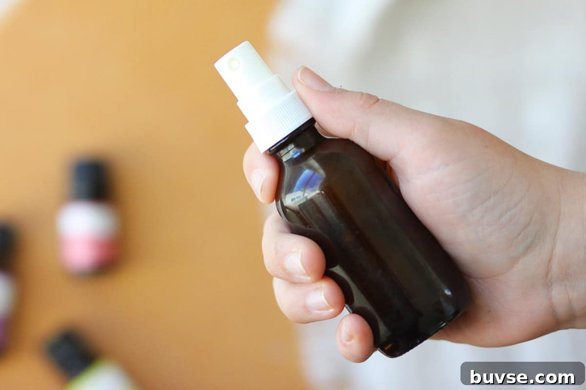 10 DIY Essential Oil Air Freshener Spray Recipes 3 a small glass amber spray bottle with essential oils on the table behind it