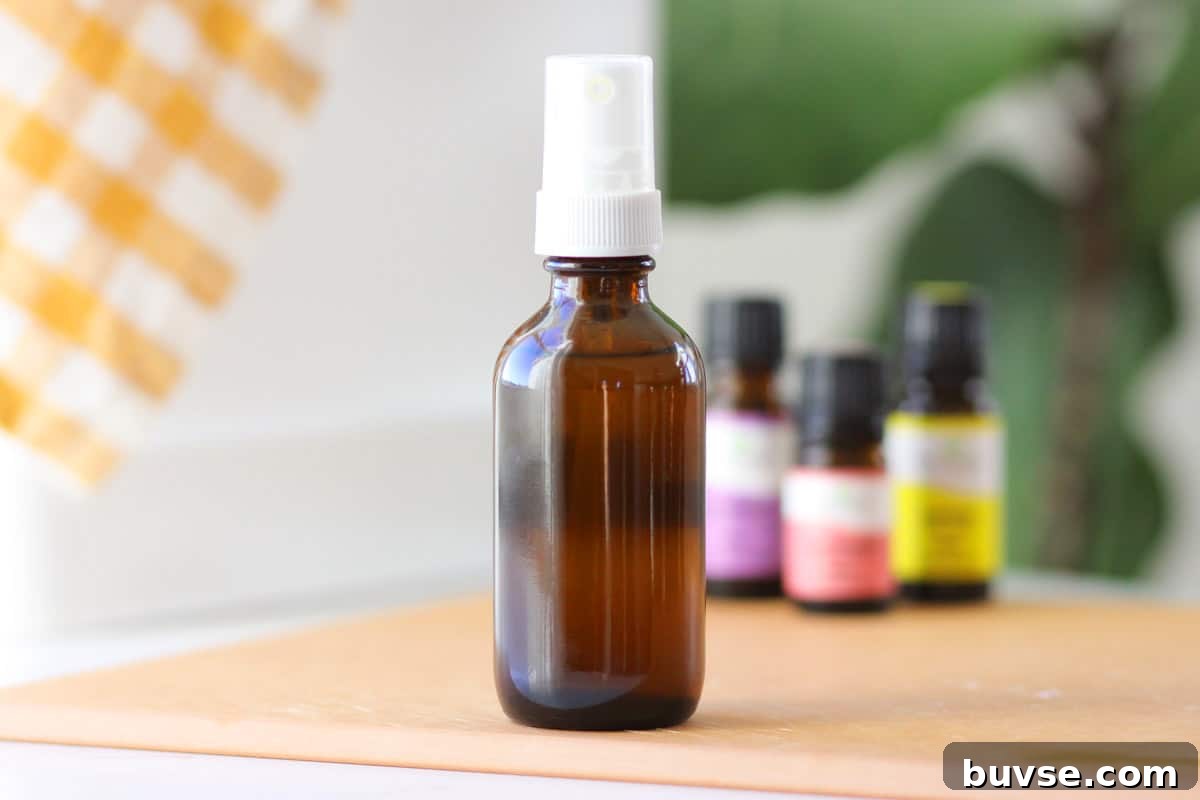 10 DIY Essential Oil Air Freshener Spray Recipes 4 a small glass amber spray bottle with essential oils on the table behind it