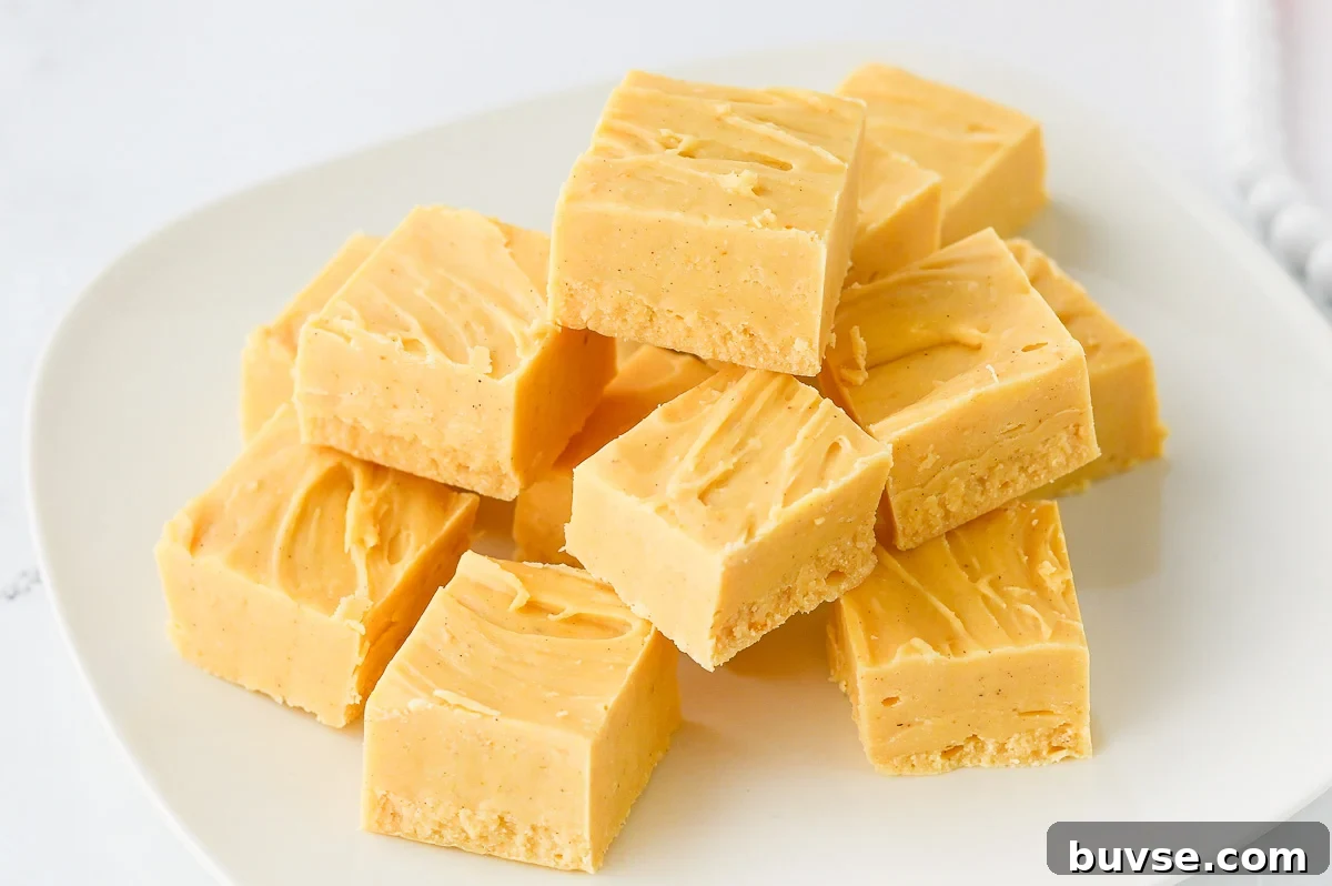 Creamy pumpkin fudge stacked on a white plate.