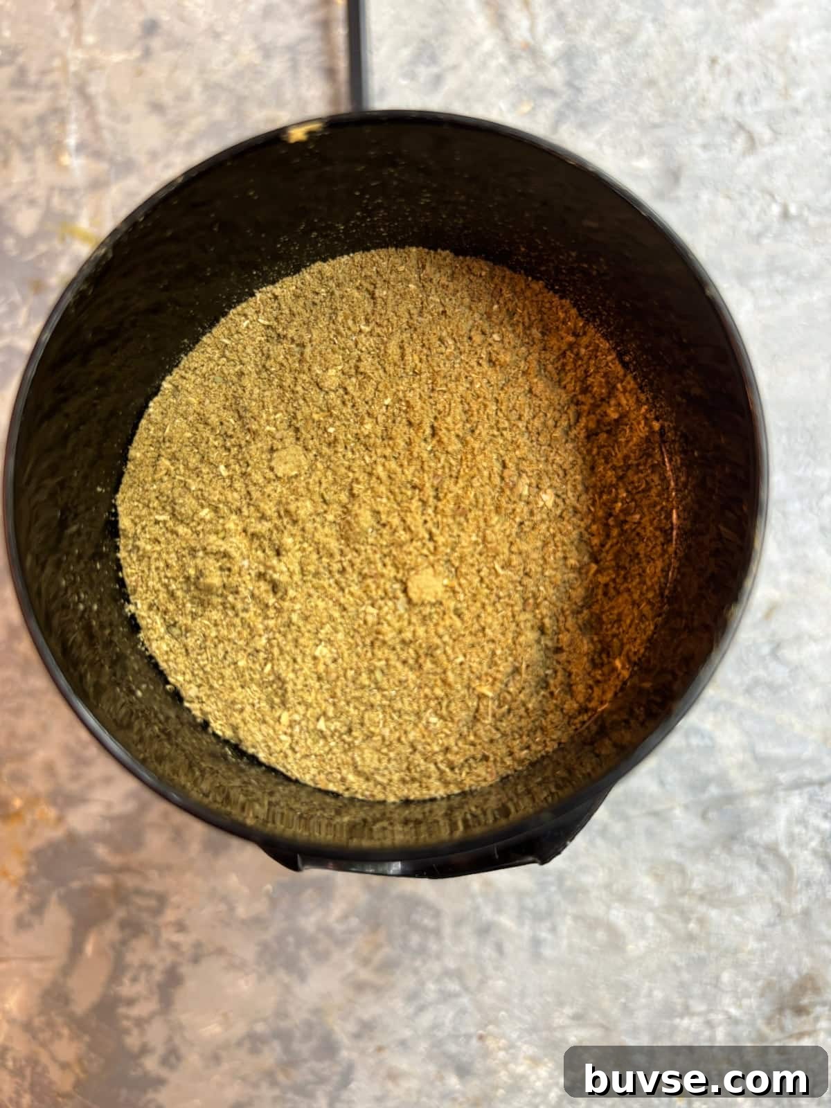overhead image of fennel, cumin, and coriander seeds after being blended in a spice blender