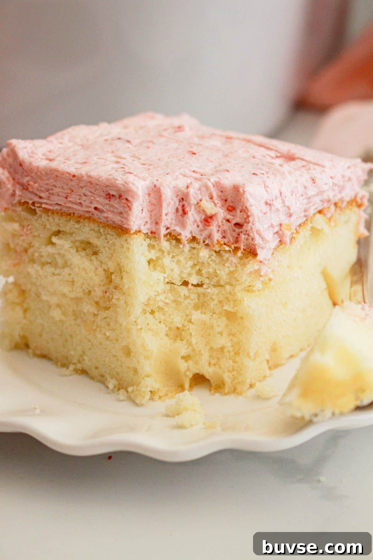 Vanilla Sheet Cake Recipe with Strawberry Frosting 3 Slice of cake on a small plate.