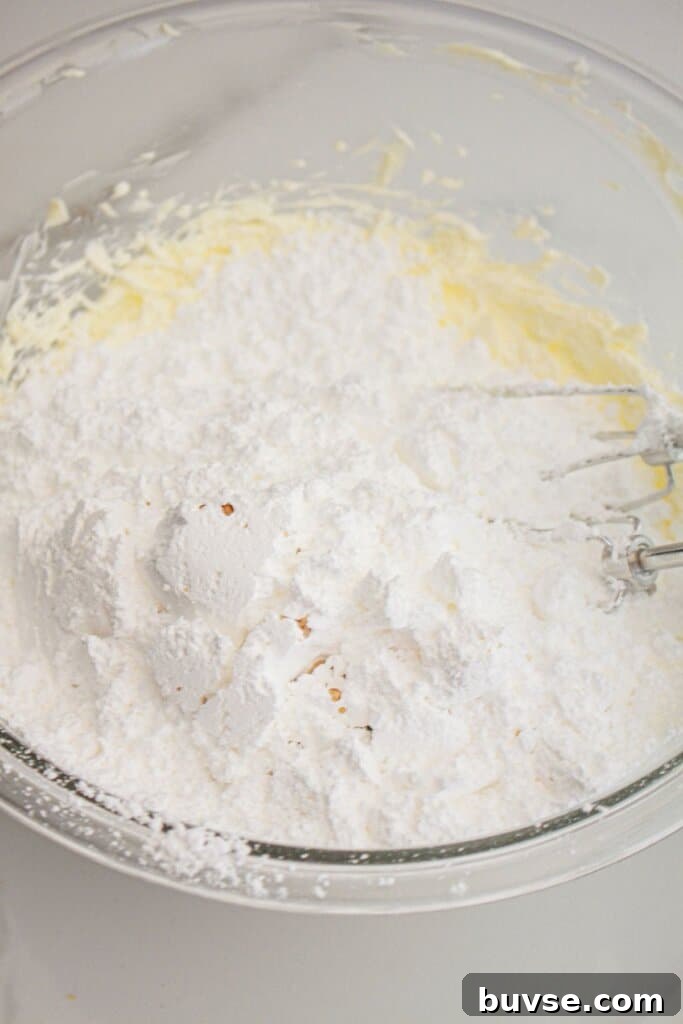 Vanilla Sheet Cake Recipe with Strawberry Frosting 8 Powdered sugar being added to creamed butter.