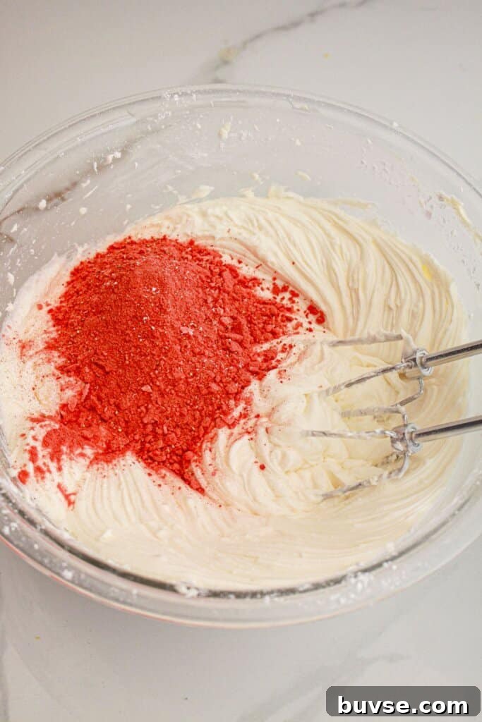 Vanilla Sheet Cake Recipe with Strawberry Frosting 9 Freeze-dried strawberries being added to icing.