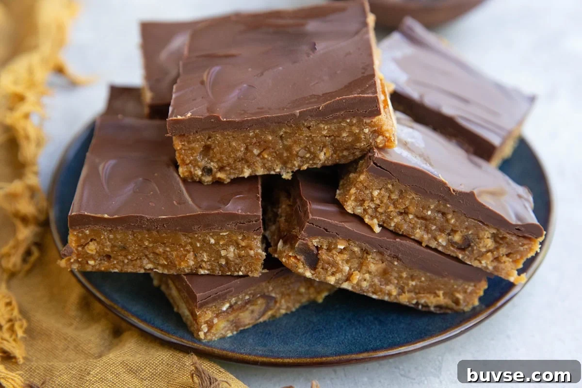 Stack of chocolate covered protein bars on a blue plate with a golden napkin.