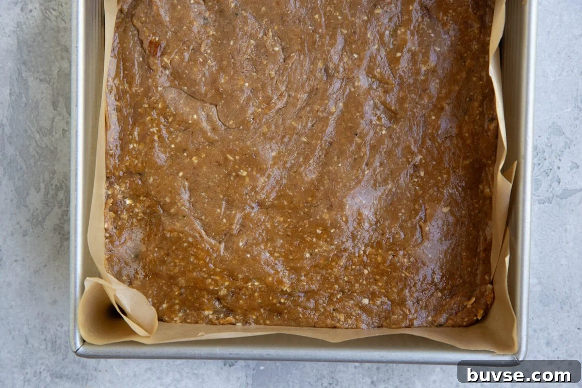 Baking pan with peanut butter mixture pressed inside to make peanut butter protein bars.