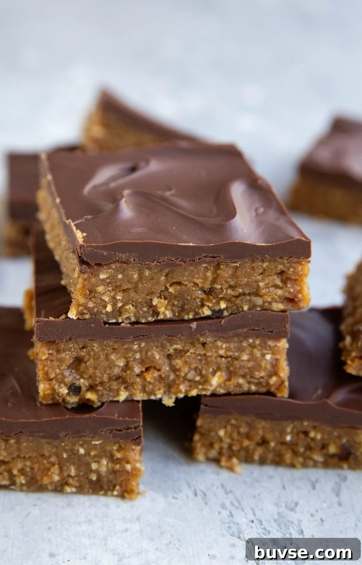 Peanut Butter protein bars stacked on top of one another with a chocolate layer on top. Ready to eat.